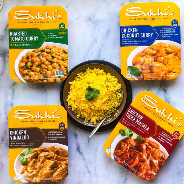 Sukhi's Entrees on display with lemon rice in a bowl in the center. 